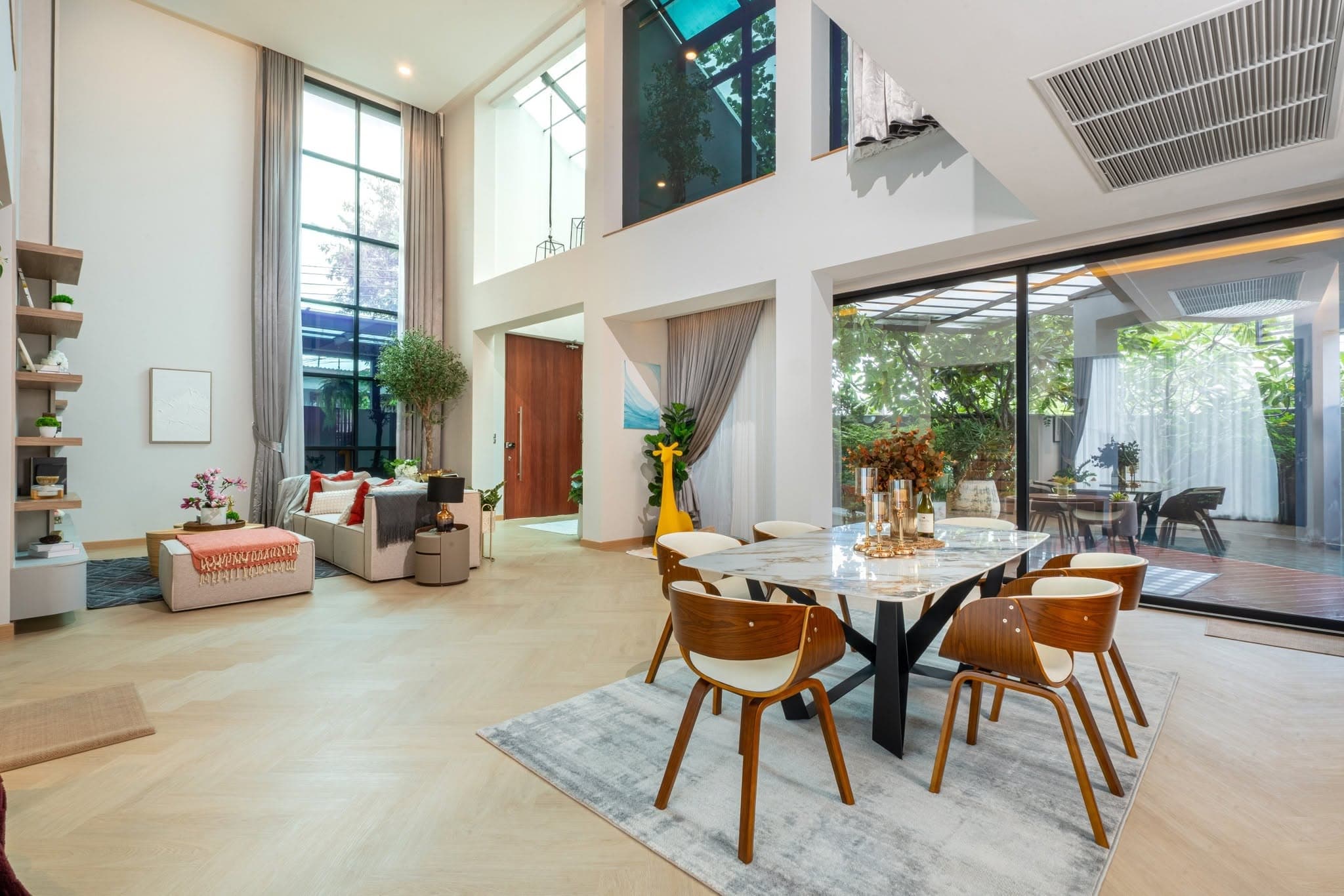 Dining area beneath a full-height glass wall